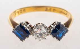 A sapphire and diamond three stone ring, claw set to the centre with an old-cut diamond,