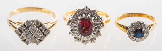 A group of three rings, including a ring claw set with multiple circular-cut cubic zirconia,