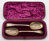 A cased matched pair of George III silver gilt peacock spoons, one by Thomas Dicks London 1807,