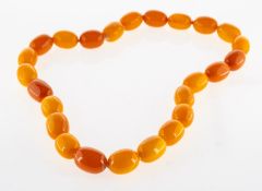 An 'amber type' bead necklace, a string of oval 'amber type' beads, knotted, no clasp,