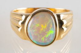 An opal ring, collet set with an opal cabochon, line carved shoulders, marked 585, size P, 4.7grams.