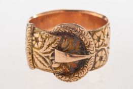 An antique 9ct gold buckle ring, with floral and foliate carving all the way around the band,