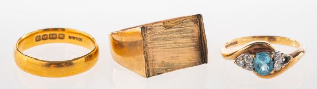 A group of three rings, including a 22ct gold wedding band, UK hallmark, size L1/2, 4.