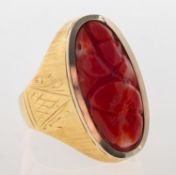 A carved coral ring, collet set with an oval floral carved piece of coral,