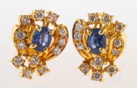 A pair of sapphire and diamond earrings, each claw set with an oval-cut sapphire,