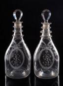 A pair of Masonic clear glass decanters of tapering oviform with triple neck rings engraved with