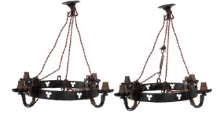 A pair of black painted wrought iron four light electroliers, in Gothic taste,