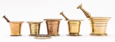 An English brass mortar, early 19th century; the mortar of tapered cylindrical form with flared rim,