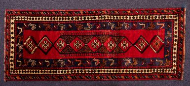 A Lori runner, the brick red field with a central elongated hooked lozenge medallion,