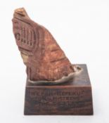 An Egyptian red quartzite stone fragment with carved inscription, 12 x 8cm, set on a wooden base,