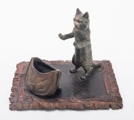 A cold painted bronze desk stand modelled with a cat standing above a creel,