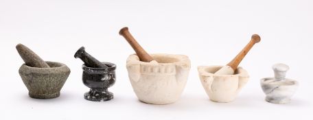 A collection of five stone mortars with pestles,