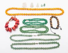 A mixed group of Chinese jade, amber, agate and other stone pendants and bead necklaces.