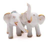 An Asian miniature porcelain double elephant group decorated in famille rose enamels, iron-red mark,