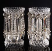 A pair of clear glass table lustres of typical form with cut decoration and hung with a double row