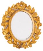 A North Italian carved and giltwood framed oval wall mirror in 18th Century style,
