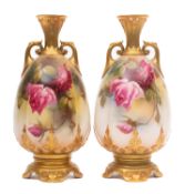 A pair of Royal Worcester porcelain vases of footed and lobed oviform with scrolling handles and