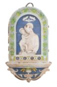 A Cantagalli 'Della Robbia' plaque of arched form modelled with the Virgin and Child,