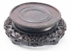 A Chinese Huanghuali wood stand, late Qing dynasty carved and pierced with foliage,