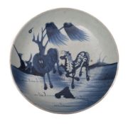 A Chinese porcelain shallow dish painted with two horses in a landscape,