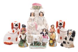 A mixed group of Staffordshire pottery spaniels, taper vase groups and figures,