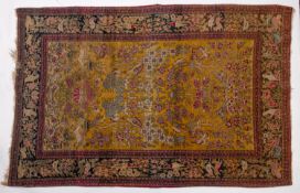 A Kirman rug, the biscuit field with an all over design of animals and birds amidst flowering trees,