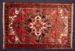 A Heriz rug, the brick red field with a large central flowerhead pole medallion,