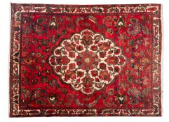 A Hamadan Rug, the wine field with a central ivory shaped oval medallion,