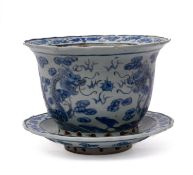 A Chinese blue and white plant pot and stand enamelled in blue with dragons pursuing sacred pearls