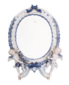 A Helena Wolfsohn porcelain mirror, the oval frame moulded with a laurel wreath,