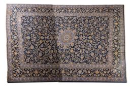 A Kashan carpet, the indigo field with a central powder blue radiating flowerhead pole medallion,