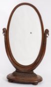 A carved walnut cheval mirror in Empire style,