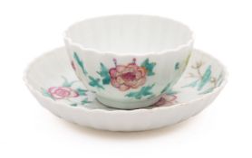 A Chinese famille rose tea bowl and saucer, Qianlong of fluted form, painted with peony sprays,