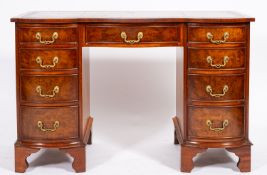 A walnut serpentine front pedestal desk in George III style,