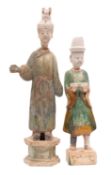 Two large Chinese Tang pottery court attendants the taller with elaborate hat and flowing robes