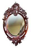 A carved and stained walnut oval wall mirror in 18th century taste,