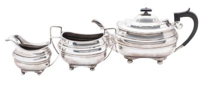 An Edwardian three-piece silver tea set, with rounded oblong bodies, gadrooned borders,