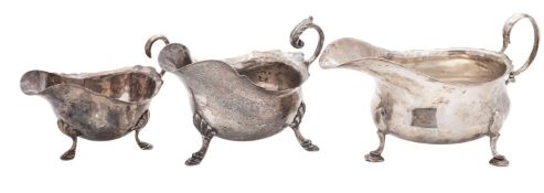 Three silver sauce boats, oval form, with wavy rims and scroll handles, by three different makers,