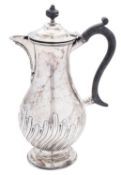 A late Victorian silver hot water jug, of baluster form, with a wrythen-fluted lower body,