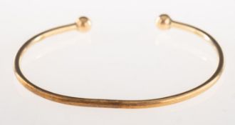 A 9ct gold torque bangle, UK hallmark, inner diameter approx. 5.9cm, (oval in shape), 9.1grams.
