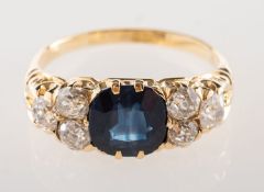 An antique sapphire and diamond ring, claw set to the centre with a cushion-cut sapphire,