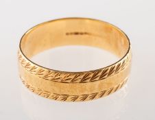 An 18ct gold wedding band, carved pattern edges with a slight hammered finish centre, UK hallmark,