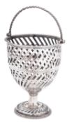 A George III silver swing-handled sugar basket, with pieced decoration, a corded handle,