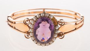 A Victorian amethyst and pearl hinged bangle,