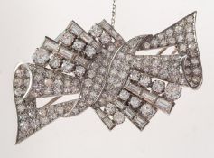 An Art Deco diamond double clip brooch, of geometric stylised ribbon design,