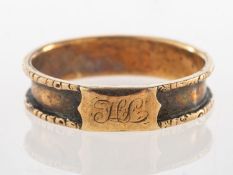 An antique mourning ring, with carved detailed edges and a monogrammed plaque, hairwork missing,