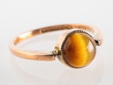 An early 20th century 9ct gold tiger's eye ring, set with a circular tiger's eye cabochon,