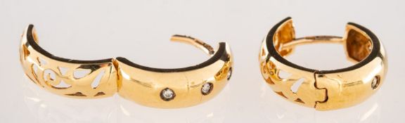 A pair of diamond hoop earrings, each set with three brilliant-cut diamonds,