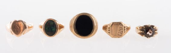 A group of five rings, including a 9ct gold signet ring with an oval green hardstone,