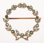 An antique diamond and emerald brooch, of wreath form,